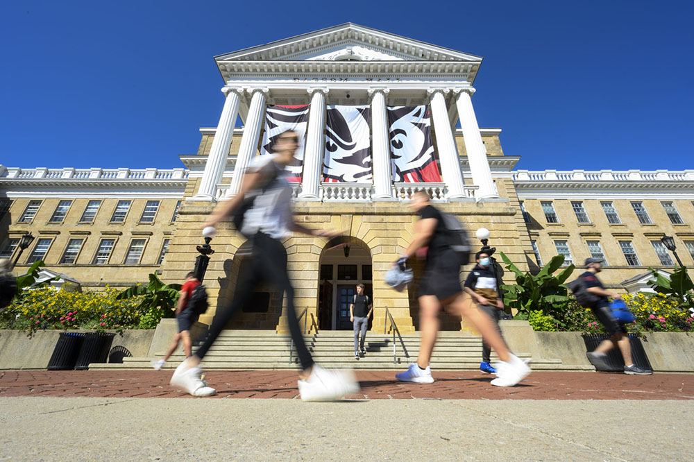 Students and pedestrians walk in front of Bascom Hall